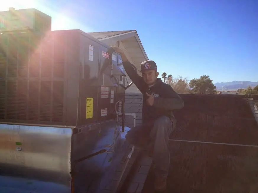 HVAC technician performing AC Tune-Up on a rooftop unit in Sonterra