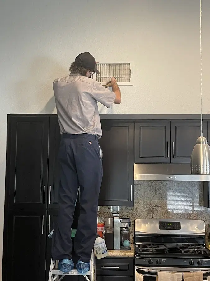 Technician inspecting an air vent during HVAC service in Sonterra